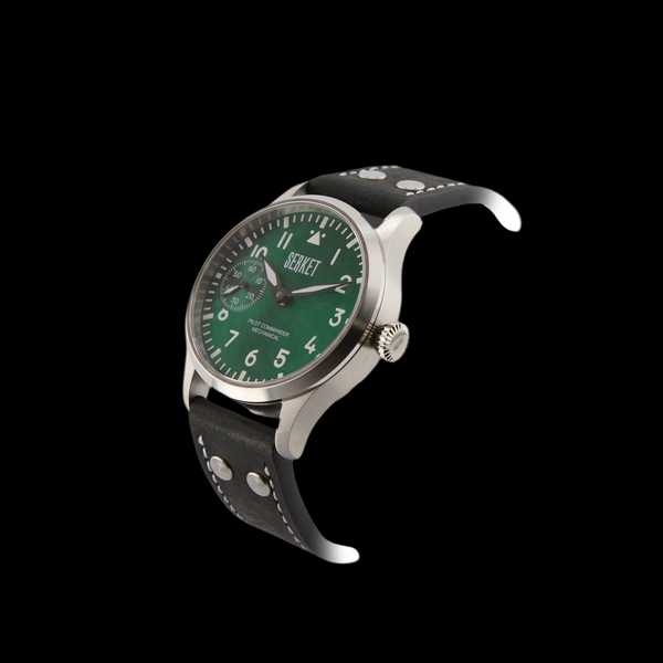 Watch with green dial and black strap on black background