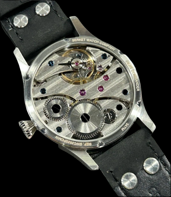 Close-up of a mechanical watch with visible brand name on a dark background