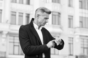 A man looks at his newly fitted watch from Serket Watch Company on the street